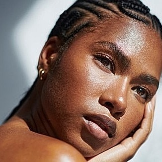 Woman with braided hair, thoughtful expression, natural light
