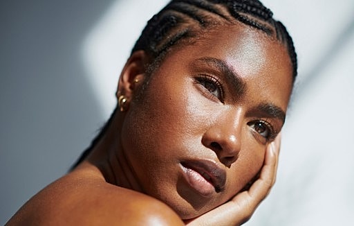 Portrait of person with braided hair and serene expression.
