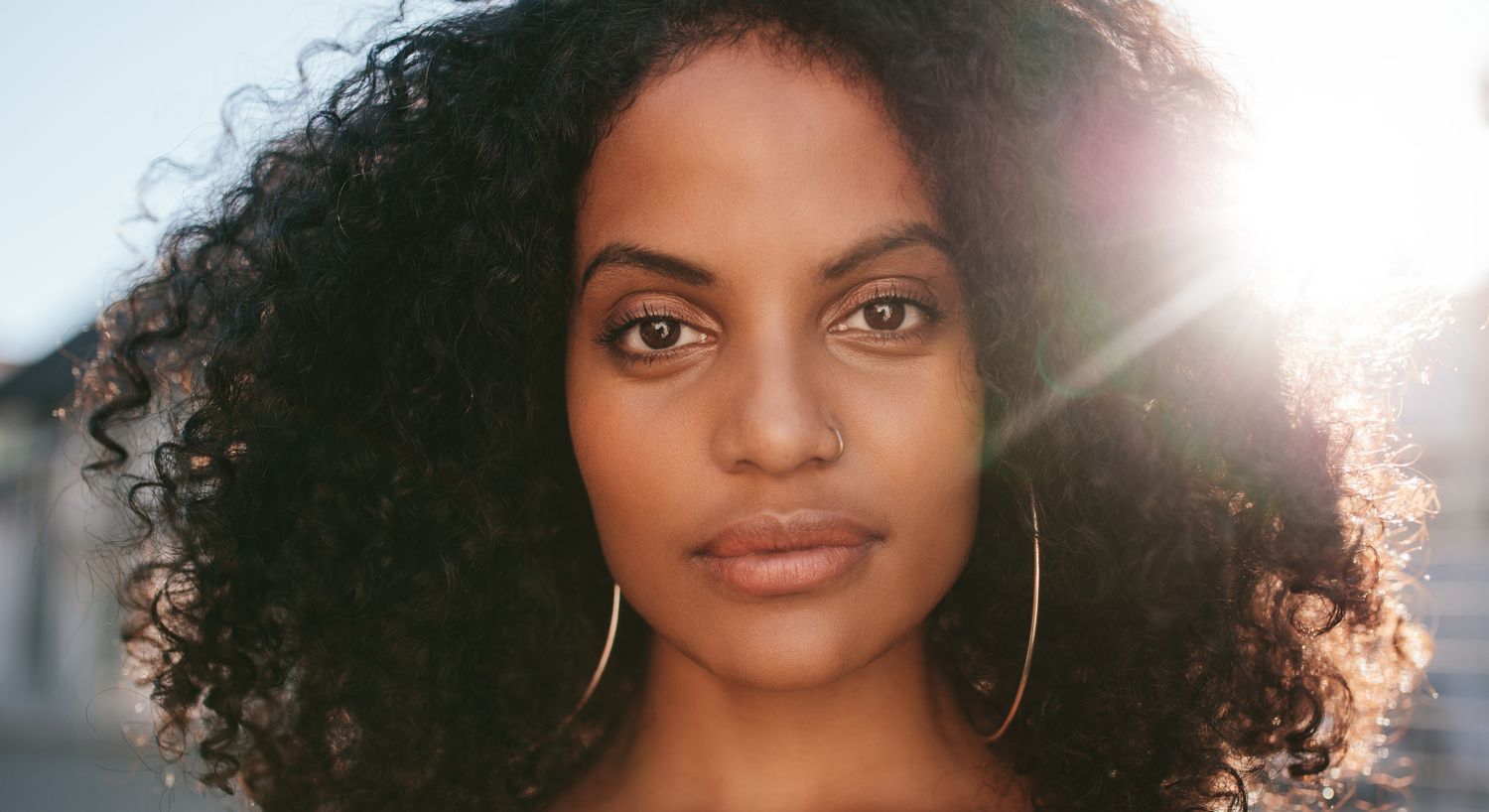Woman with curly hair and natural makeup.